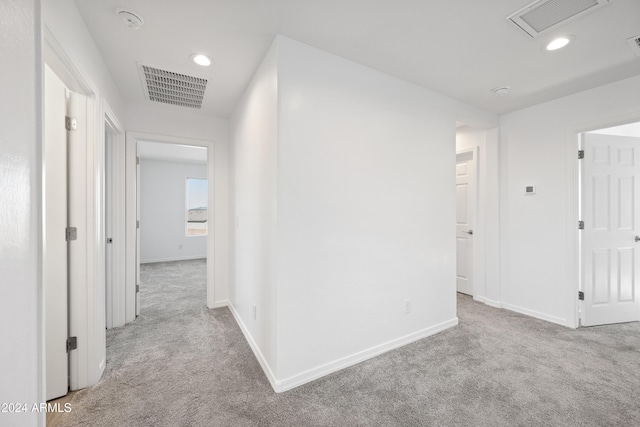 hallway with carpet floors, recessed lighting, visible vents, and baseboards