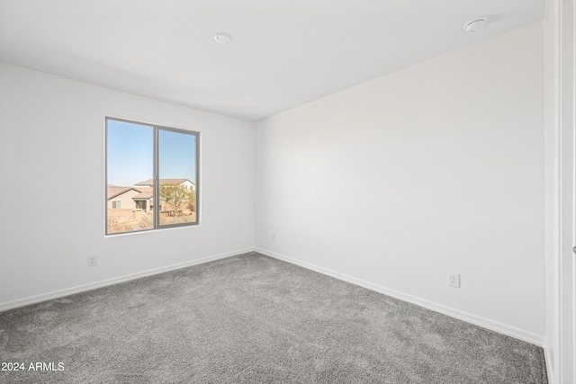 carpeted spare room featuring baseboards