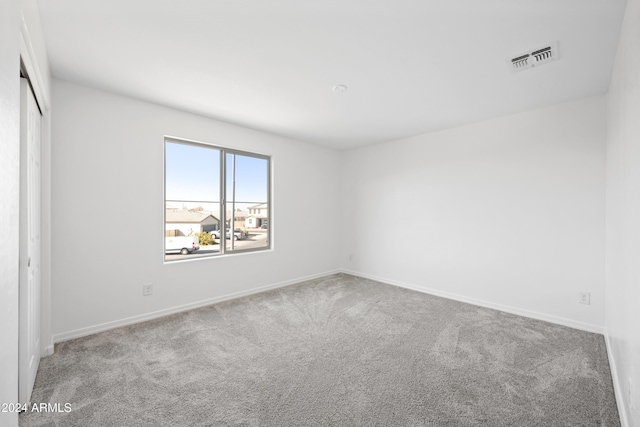 spare room with baseboards, visible vents, and carpet flooring