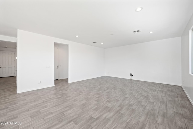 empty room with recessed lighting, visible vents, light wood-style flooring, and baseboards