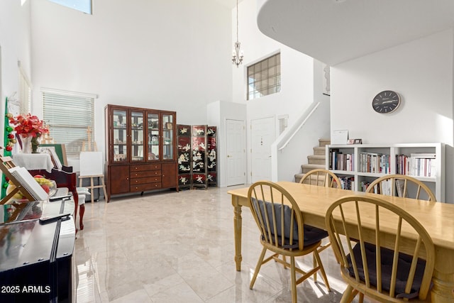 dining room with a towering ceiling and a notable chandelier