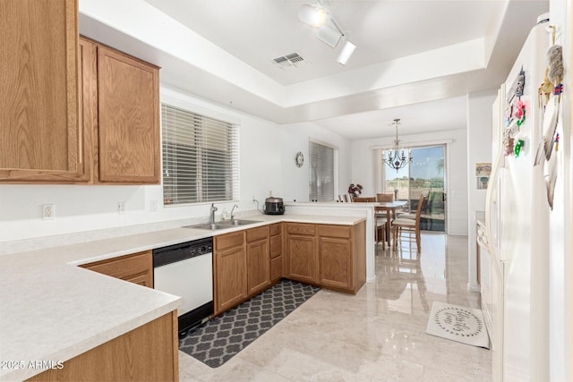 kitchen with pendant lighting, sink, kitchen peninsula, a raised ceiling, and white appliances