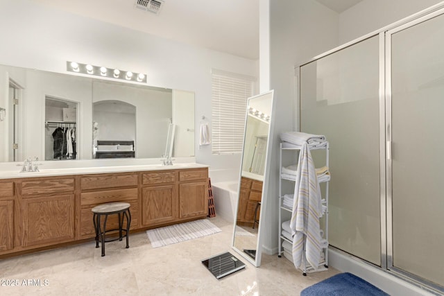 bathroom featuring vanity and independent shower and bath