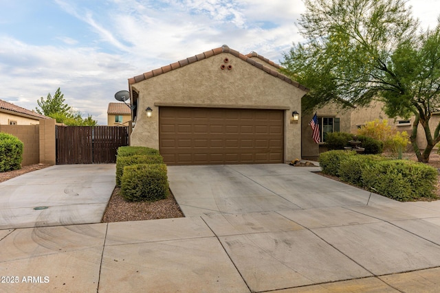 mediterranean / spanish-style home with driveway, a tiled roof, an attached garage, and stucco siding