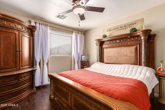 bedroom with dark hardwood / wood-style flooring, ceiling fan, and a textured ceiling