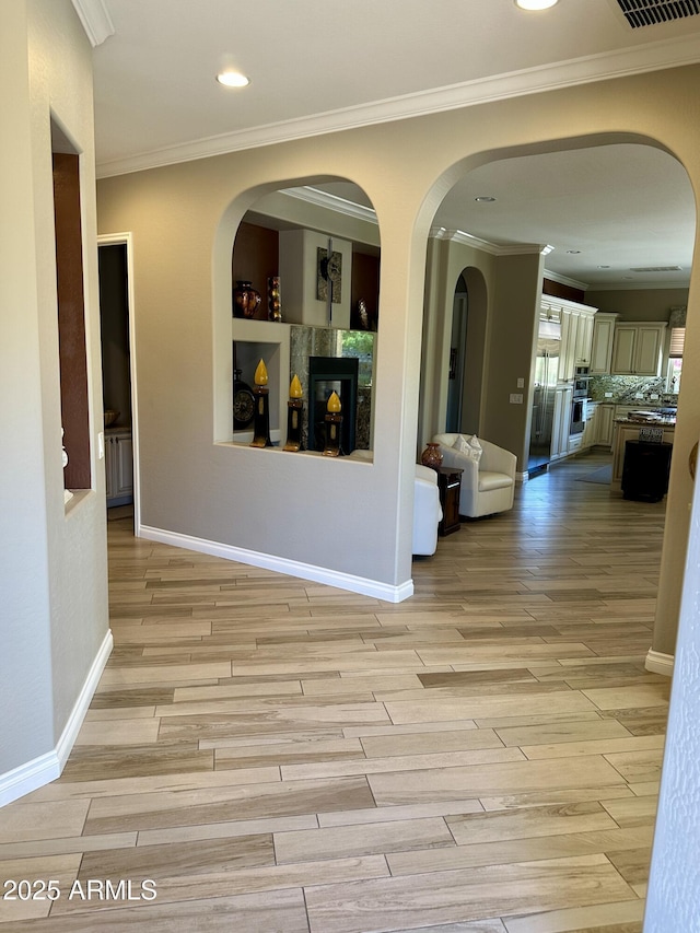 562 E Vesper Trl, Queen Creek, AZ 85140 - hallway featuring light wood finished floors, crown molding, recessed lighting, baseboards, and arched walkways