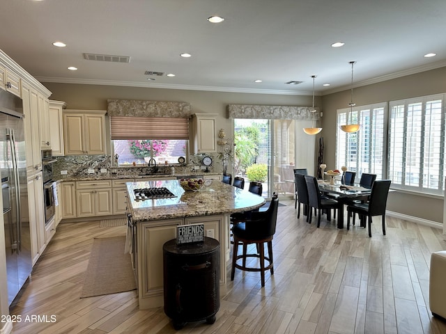 562 E Vesper Trl, Queen Creek, AZ 85140 - kitchen featuring a kitchen island, a kitchen bar, appliances with stainless steel finishes, decorative backsplash, and light stone counters