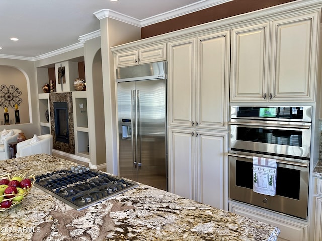 562 E Vesper Trl, Queen Creek, AZ 85140 - kitchen featuring appliances with stainless steel finishes, arched walkways, crown molding, and light stone countertops
