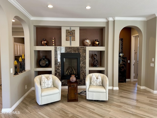 562 E Vesper Trl, Queen Creek, AZ 85140 - sitting room featuring light wood-type flooring, arched walkways, crown molding, baseboards, and a premium fireplace