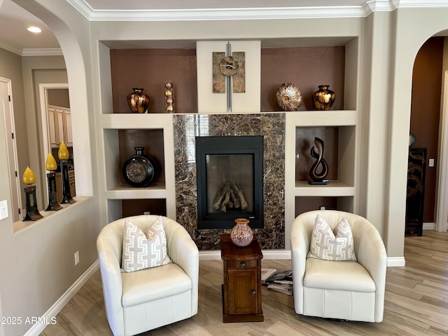 562 E Vesper Trl, Queen Creek, AZ 85140 - living area with arched walkways, built in shelves, crown molding, baseboards, and wood finished floors