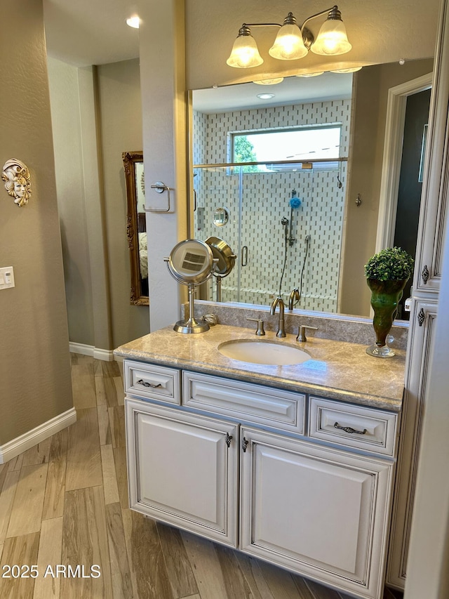 562 E Vesper Trl, Queen Creek, AZ 85140 - bathroom featuring vanity, a shower stall, wood finished floors, and baseboards