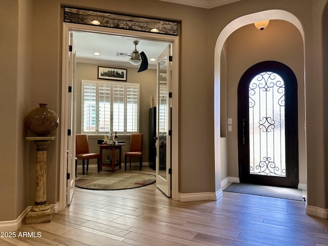 562 E Vesper Trl, Queen Creek, AZ 85140 - foyer entrance with light wood finished floors, arched walkways, crown molding, and baseboards
