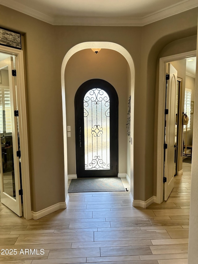 562 E Vesper Trl, Queen Creek, AZ 85140 - foyer featuring arched walkways, plenty of natural light, light wood-type flooring, and ornamental molding