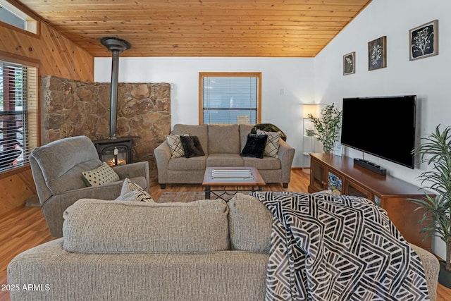 living room with wood ceiling, vaulted ceiling, wood finished floors, and a wood stove