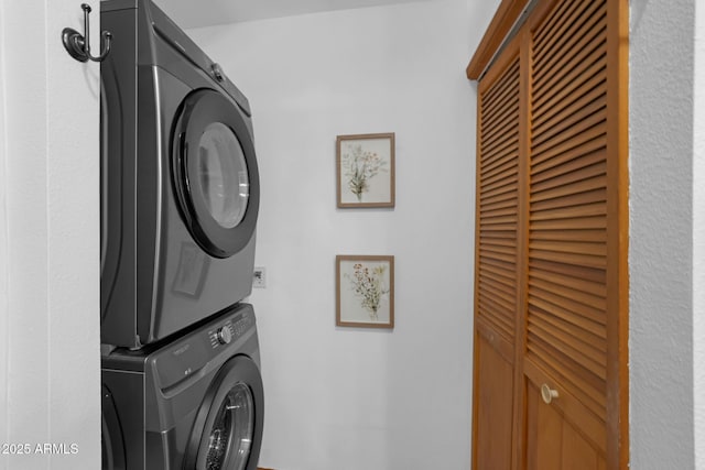 laundry area featuring stacked washer / dryer and laundry area