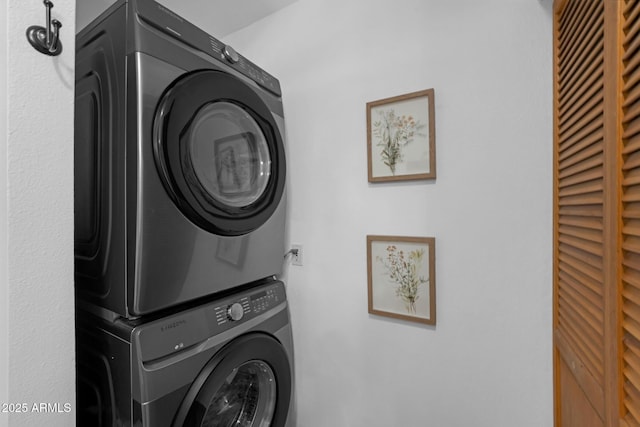 clothes washing area featuring stacked washer / dryer