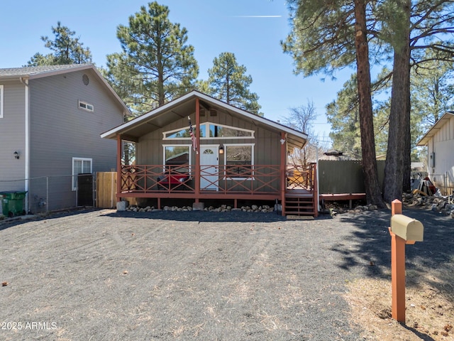 view of front facade featuring a wooden deck, fence, and board and batten siding