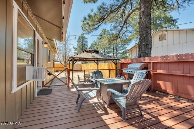 deck featuring a fenced backyard, a grill, a gazebo, cooling unit, and an outdoor fire pit