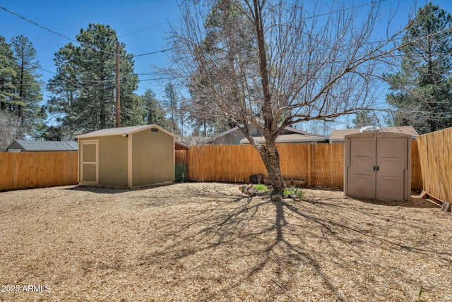 view of yard with a storage shed, a fenced backyard, and an outdoor structure