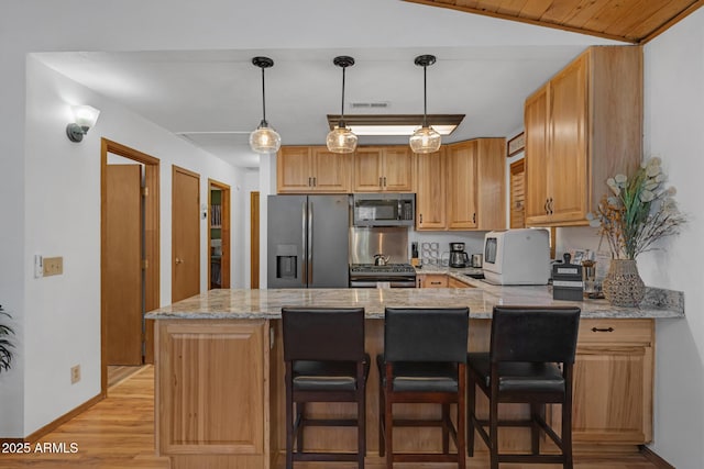 kitchen featuring light stone counters, light wood-type flooring, a peninsula, baseboards, and appliances with stainless steel finishes