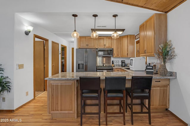 kitchen featuring light wood finished floors, stainless steel appliances, baseboards, and light stone countertops
