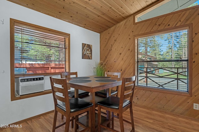 dining space featuring wooden ceiling, baseboards, wood finished floors, and wooden walls