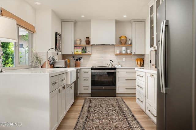 8068 E Del Trigo Rd, Scottsdale, AZ 85258 - kitchen featuring stainless steel appliances, open shelves, decorative backsplash, light countertops, and light wood finished floors