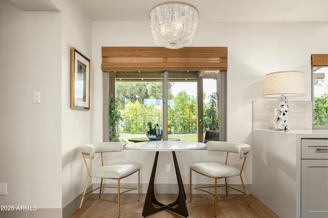 8068 E Del Trigo Rd, Scottsdale, AZ 85258 - dining room with light wood-type flooring and a chandelier