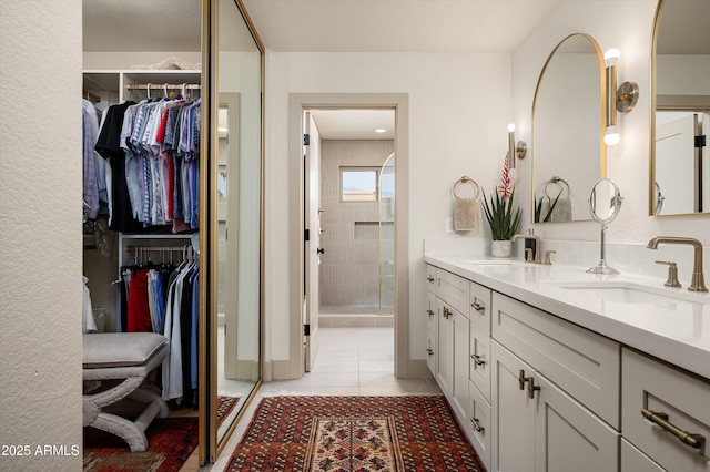 8068 E Del Trigo Rd, Scottsdale, AZ 85258 - bathroom with double vanity, a stall shower, a walk in closet, and tile patterned floors