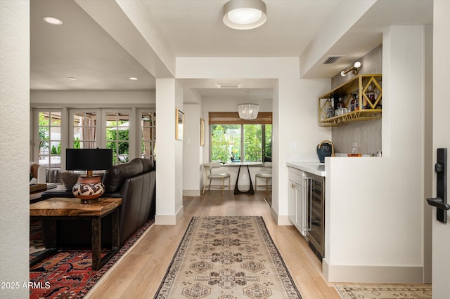 8068 E Del Trigo Rd, Scottsdale, AZ 85258 - indoor dry bar with beverage cooler, light wood-style floors, and recessed lighting