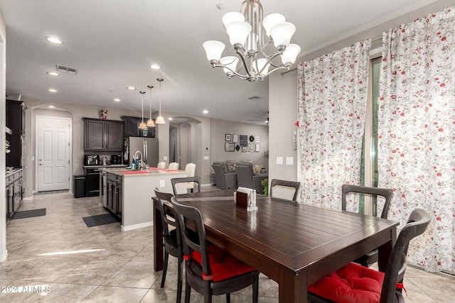 dining area featuring ceiling fan with notable chandelier and sink