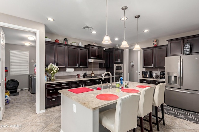 kitchen with sink, pendant lighting, a breakfast bar, a center island with sink, and appliances with stainless steel finishes