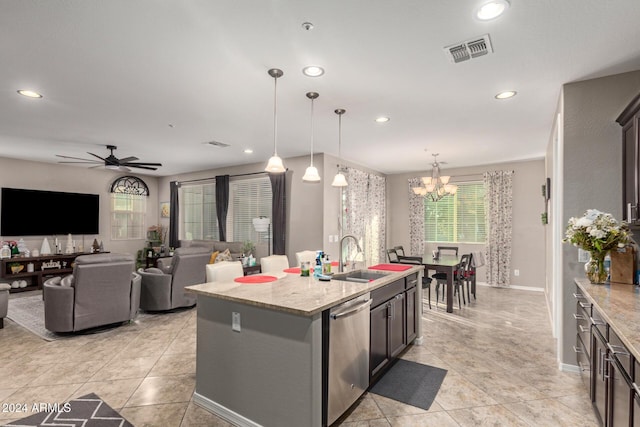 kitchen featuring light stone counters, sink, a center island with sink, dishwasher, and hanging light fixtures