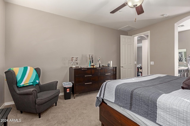 carpeted bedroom with connected bathroom and ceiling fan