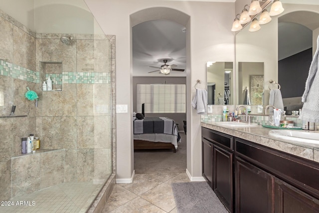 bathroom featuring tile patterned floors, ceiling fan, a tile shower, and vanity