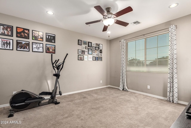 exercise area with ceiling fan and light colored carpet