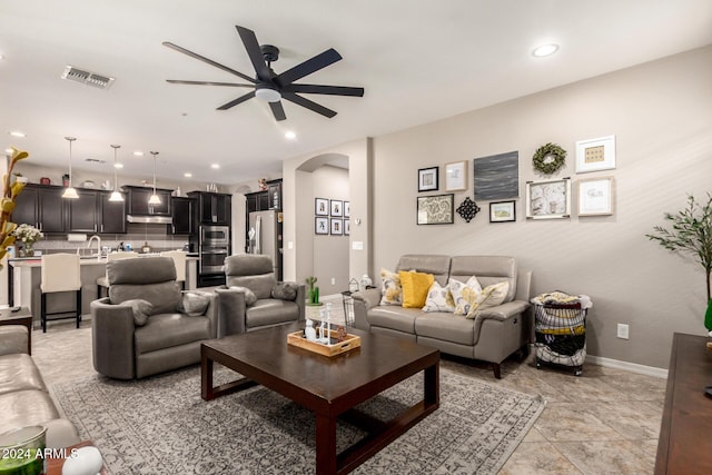 living room with ceiling fan and sink