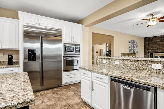 kitchen with ceiling fan, white cabinets, and built in appliances