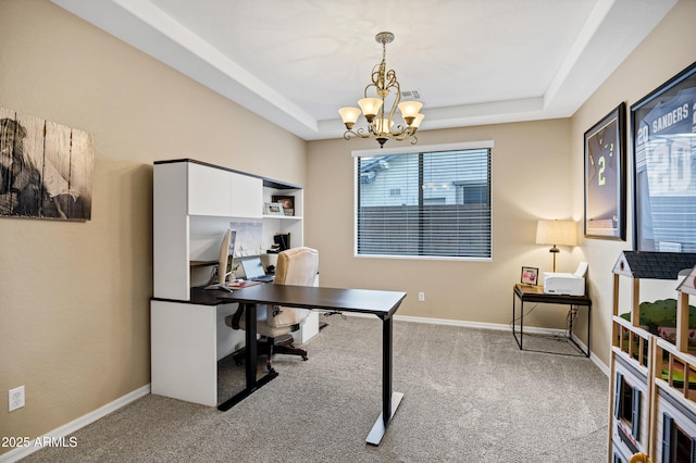 office space with a raised ceiling, light carpet, and a chandelier