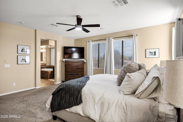 carpeted bedroom with ensuite bath and ceiling fan