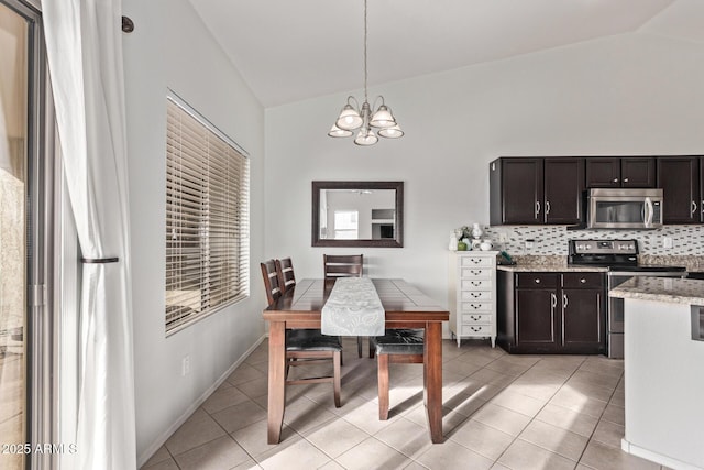 tiled dining space with vaulted ceiling and a notable chandelier