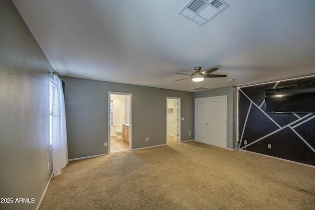 unfurnished bedroom with a ceiling fan, connected bathroom, light carpet, baseboards, and visible vents