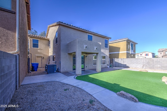 rear view of property with a tile roof, a fenced backyard, central AC unit, a patio, and stucco siding