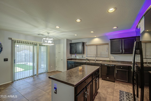 kitchen with dark countertops, a sink, a chandelier, light tile patterned floors, and dishwasher