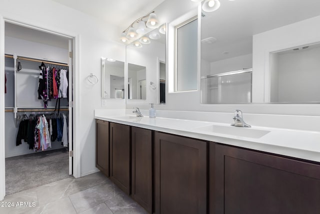 bathroom featuring vanity and a shower with door