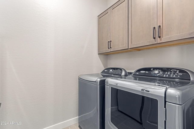 laundry room with independent washer and dryer and cabinets