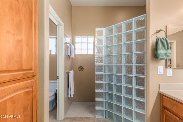 bathroom featuring vanity, toilet, a shower, and tile patterned flooring