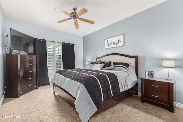 bedroom with ceiling fan, baseboards, and light colored carpet