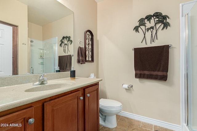 bathroom featuring toilet, a shower stall, baseboards, and vanity