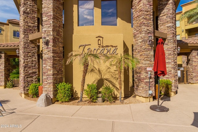 entrance to property featuring stone siding and stucco siding